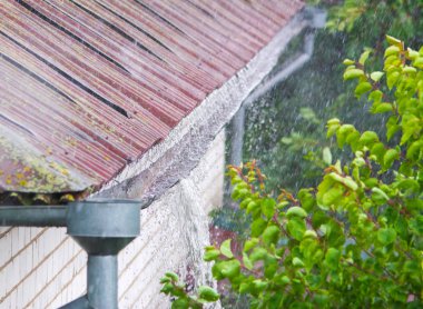 Heavy rain. Rainwater pouring out of old downspout clipart