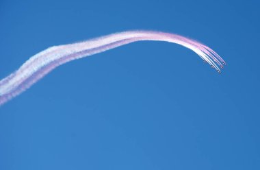 Akrobasi takımı formasyon uçan ve mavi gökyüzünde beyaz pembe duman izi bırakarak