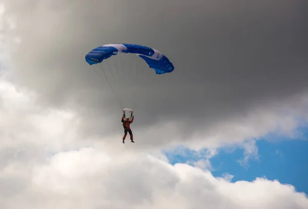 Paracaidista en el cielo nublado, salto en paracaídas — Foto de Stock