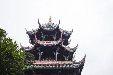 Pagoda bina çatı detayları ve ağacın önünde. Katmanlı çatı, renkli çatı Zona ve ayrıntılı süs eşyaları ve dekorasyonlar.