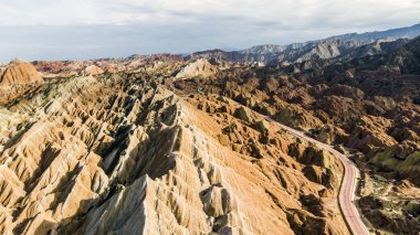 Gökkuşağı dağlar jeolojik Park. Çizgili Zhangye Danxia ılık jeolojik Park Gansu Eyaleti, Çin. Turist otobüsleri güneşli bir günde bir vadide bir yolda.