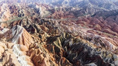 Üstten Görünüm gökkuşağı dağlar jeolojik park. Çizgili Zhangye Danxia ılık jeolojik Park Gansu Eyaleti, Çin. Yol bir vadide güneşli bir resmini uçak.