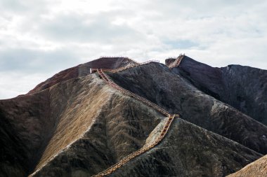 Uzun merdiven dağ tepesine yol açmaktadır. Kimse tepeye yürüme mesafesindedir. Çıplak yamaçta güneşli bir gün.