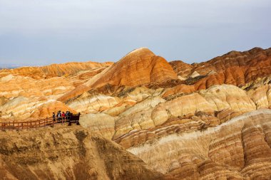 Platform ile ilgilenen ve Top gökkuşağı dağlar jeolojik Park Çin turist vardır. Çizgili Zhangye Danxia ılık jeolojik Park Gansu Eyaleti, Çin. Gözlem güverte, Sharp tepeler ve Vadisi güneşli bir günde insanlar.