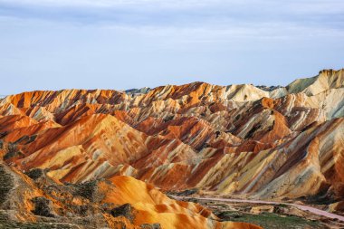 Gökkuşağı dağlar jeolojik Park inanılmaz renkli görünümü. Çizgili Zhangye Danxia ılık jeolojik Park Gansu Eyaleti, Çin. Güneşli bir günde keskin tepeler ve yol bir vadide.