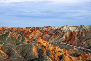 Gökkuşağı dağlar jeolojik Park olağanüstü manzarası. Çizgili Zhangye Danxia ılık jeolojik Park Gansu Eyaleti, Çin. Güneşli bir günde keskin tepeler ve yol bir vadide.