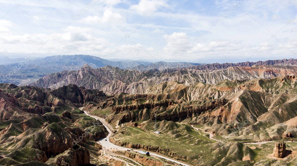 Aerial View from Drone of Binggou Danxia Canyon Landform in Zhangye, Sunan Region, Gansu Province, China. Sharp Pointy Peaks in the Geopark. Road on Valley on a Sunny Day.