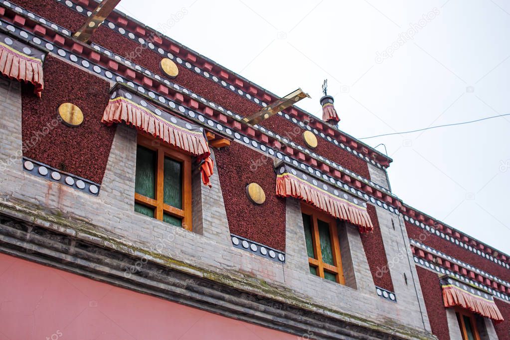 Colorful Tibetan Architecture. Detailed Facade of Top Floor of Traditional Buddhist Building. Red Chinese Windows.