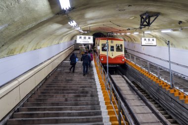 Dik yamaç üzerinde yeraltı tramvay ve insanlar tünelde tırmanma