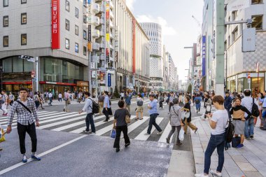 İnsanlar Tokyo 'da Ginza Caddesi' ni geçiyor..