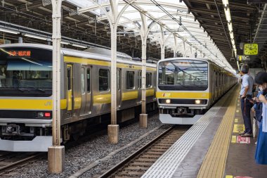 Tren Tren Tren İstasyonu 'na varmak üzere ve insanlar platformda..