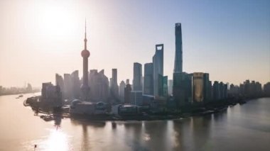 Güneşli Gün Hızlandırması ya da Doğu İnci Kulesi Finansal Bölgesi Pudong 'un hiper hızlandırılmış hava görüntüsü. Bund Huangpu Nehri üzerindeki Şangay Kulesi. Waitan Puxi 'nin yukarısındaki şehir merkezinde gemiler geziyor..