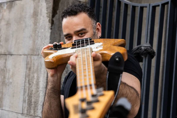 stock image Handsome Male Person is Looking Through his Bass Guitar on Street. Playful Caucasian Young Person at Outdoor Event.