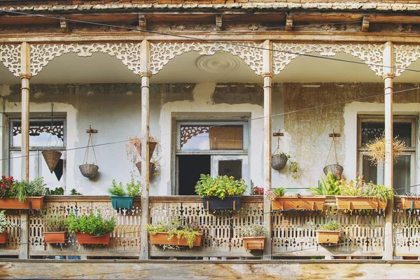 Tiflis, Gürcistan güzel teras ile eski evde. Eski geleneksel ahşap Balkon çiçek ve eski eserler çok ile dekore edilmiştir.
