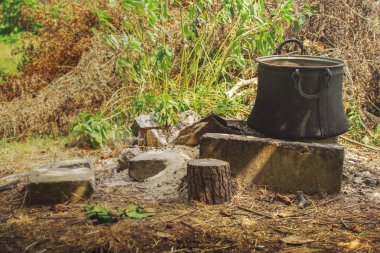 Beton tuğla şömine çiftlik arka bahçesinde üzerinde ayakta yemek pişirmek için eski bakır Tencere