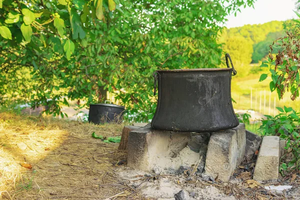 Beton tuğla şömine arka üstünde ayakta yemek pişirmek için eski bakır Tencere