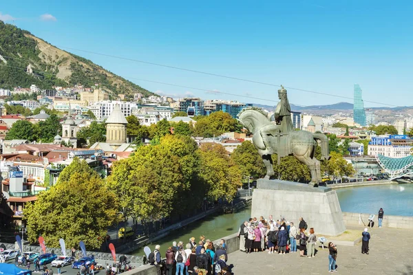 Tiflis, Gürcistan - 06 Ekim 2018: Görünümü üzerinde eski şehir manzarası Metekhi kilise Yaylası ve Kral Hatice Gorgasali at heykeli üzerinde. Popüler turistik yer. Onların tur rehberi dinleme turist.