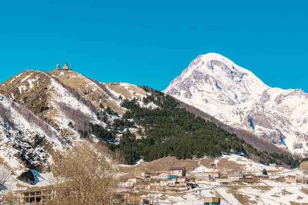 Gergeti Trinity Kilisesi (Tsminda Sameba), Holy Trinity Kilisesi Köyü Gergeti Gürcistan yüksek dağı Kazbegi arkasında - görüntü ile yukarıda