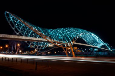 Georgia, Tiflis - 05.02.2019. -Gece görüş ışıklı ünlü köprü barış Tiflis Merkezi City üzerinden. Araba hafif trails - gece fotoğrafçılığı
