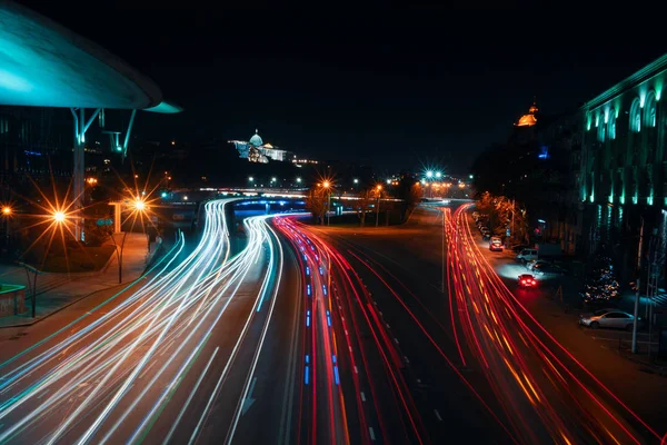 Georgia, Tbilisi - 05.02.2019. - Auto tracce di luce eccesso di velocità sulla strada accanto a Public Service Hall. Palazzo presidenziale sullo sfondo - Foto di notte — Foto Stock