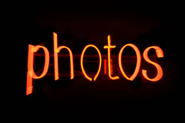 Blur Fotos mensagem em néon vermelho contra fundo preto - Imagem — Fotografia de Stock