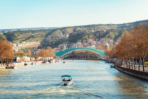 Gürcistan, Tiflis 'te sonbahar. Ünlü cam Barış Köprüsü ve antik kalenin altındaki eski kasaba üzerinde panoramik bir manzara. Nehirde kayık gezisi.