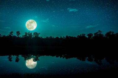 Beautiful landscape of night sky with many stars and full moon above silhouettes of trees at riverside. Serenity nature background, outdoor at nighttime. The moon taken with my camera. clipart