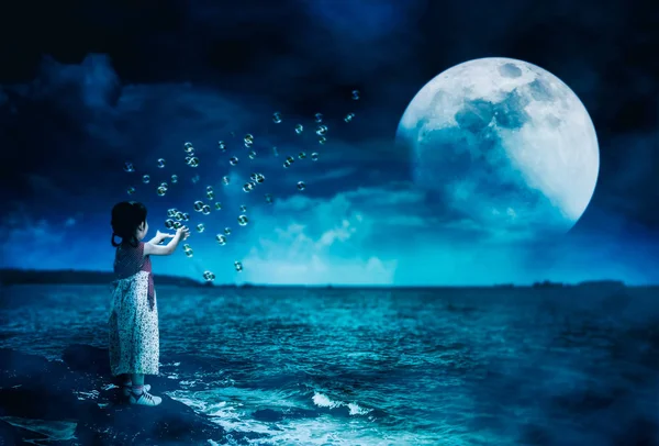 Achteraanzicht Van Aziatisch Meisje Speelt Met Zeepbellen Steen Aan Zee — Stockfoto