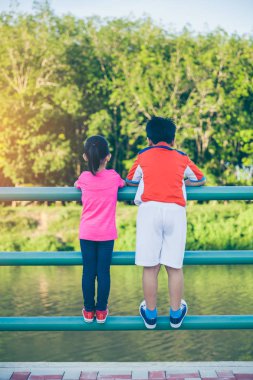 Arkadan görünüm. Asya kardeş kardeşi egzersiz sonra ile rahatlatıcı. Açık havada parlak güneş ışığı ile yaz gününde genel Park'ta. Kavramı için iyi sağlıklı egzersiz hakkında. Vintage film filtre efekti.