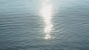 Açık deniz suyu, su yüzeyine güneş kıvılcımları. Sabah güneş ışığı yansıtan su yüzeyi dalgalanma. Pırıltı dalga, yaz günü açık üzerinde parlıyor. Bulanık arka plan.