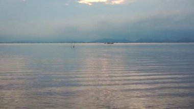 Deniz manzarası üzerinde bulutlu gökyüzü ile gündoğumu sakin sahne. Balıkçı teknesinde bir adam yelken dahil şehirlerarası içinde sabah, ses. Geleneksel Fishermans yaşam tarzının. Doğa, serenity arka plan armoni.