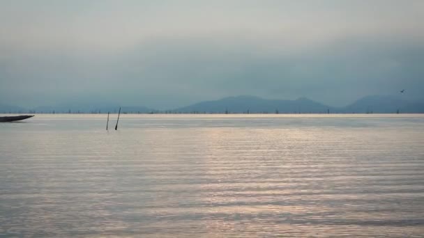 海景の曇り空で日の出の静かな情景 含まれている朝 音で長距離に帆を漁船の男性 伝統的なフィッシャーマンズな生き方 セレニティ背景自然の調和 — ストック動画