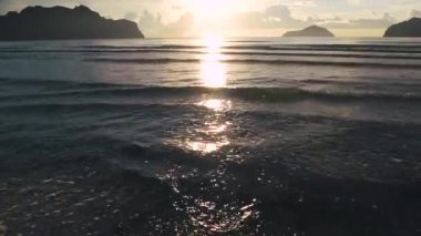 Denizde kum ve adaların manzarası ve sabahları güneş ışığı. Olay yerinde kimse yok. Film tonu. 4K UHD