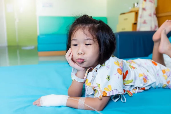 Enfermedad niño asiático ingresado en el hospital con solución salina intravenosa (IV) en la mano . —  Fotos de Stock