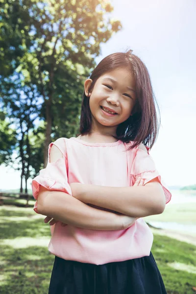 Retrato de una niña asiática sonriente en el parque . — Foto de Stock