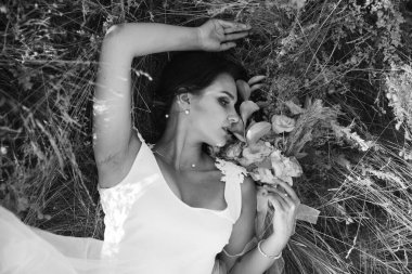 Şatafatlı beyaz ve pembe gelinlikli gelin gün batımında doğada