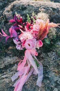 Düğün buketi gelinin elinde ve koltukta, düğün detayları ve ayakkabılar.