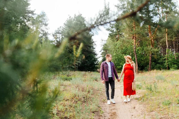 Terhes Lány Pocakkal Várja Szülést Piros Ruhában Szalmakalapban Férjével Mezőn — Stock Fotó