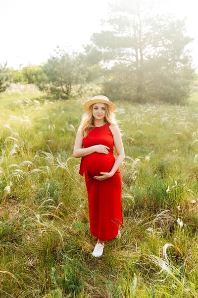 Hamile Bir Kız Karnından Doğumu Bekliyor Kırmızı Elbiseli Hasır Şapkalı — Stok fotoğraf