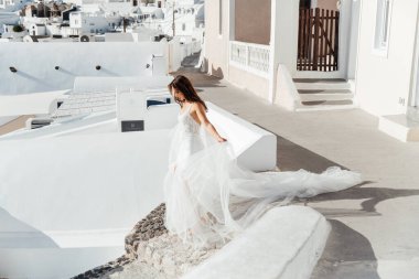 Yunanistan 'ın Santorini adasında düğün, güzel bir çift, beyaz gelinlik içinde gelin. Beyaz evler ve mavi gökyüzü