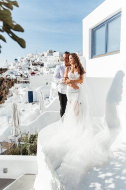Yunanistan 'ın Santorini adasında düğün, güzel bir çift, beyaz gelinlik içinde gelin. Beyaz evler ve mavi gökyüzü