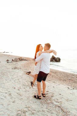 Balayı sırasında beyaz elbiseli sevimli bir çift kumsalda yürür bir fotoşop aşk hikayesi, okyanus kıyısında, plajda