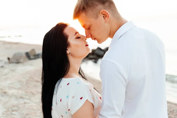 Balayı sırasında beyaz elbiseli sevimli bir çift kumsalda yürür bir fotoşop aşk hikayesi, okyanus kıyısında, plajda