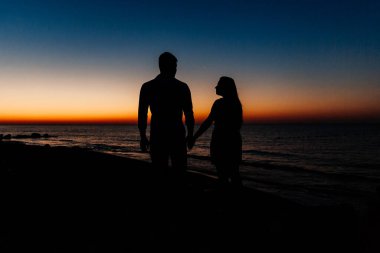 Balayı sırasında beyaz elbiseli sevimli bir çift kumsalda yürür bir fotoşop aşk hikayesi, okyanus kıyısında, plajda