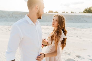 Güzel bir çiftin aşk hikayesi. Pembe bir gelinlik içinde Sahra Çölü 'nde bir buketi olan kumlar ve kumullar.