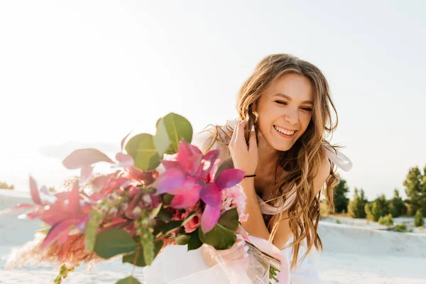 Güzel bir çiftin aşk hikayesi. Pembe bir gelinlik içinde Sahra Çölü 'nde bir buketi olan kumlar ve kumullar.