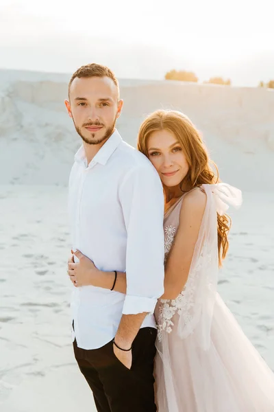 Güzel bir çiftin aşk hikayesi. Pembe bir gelinlik içinde Sahra Çölü 'nde bir buketi olan kumlar ve kumullar.