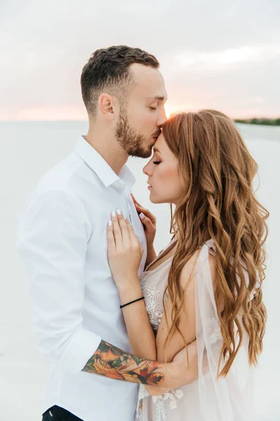 Güzel bir çiftin aşk hikayesi. Pembe bir gelinlik içinde Sahra Çölü 'nde bir buketi olan kumlar ve kumullar.