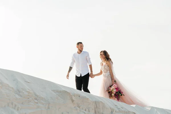 在撒哈拉沙漠 一对穿着粉色婚纱 头戴花束的年轻夫妇的爱情故事 — 图库照片
