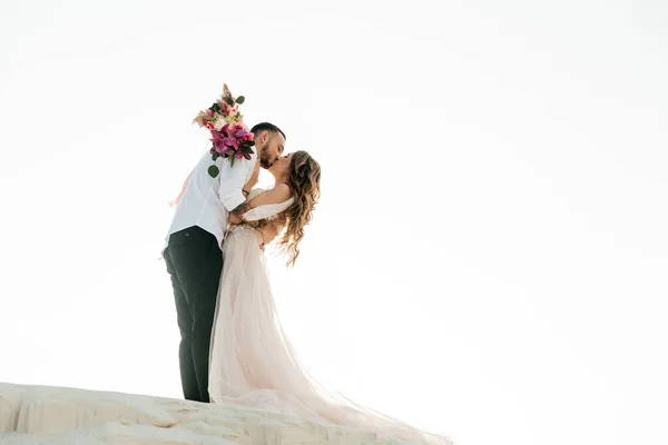 サハラ砂漠 砂丘で花束とピンクの結婚式の豪華なドレスで美しいカップルの愛の物語 — ストック写真